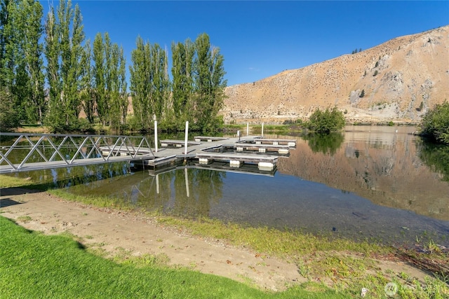 view of dock with a water and mountain view