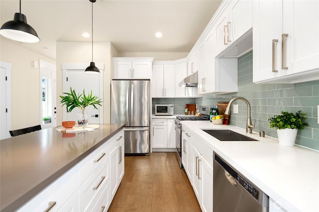 10410 2nd Pl SW, Seattle, WA 98146 - kitchen featuring white cabinets, a sink, stainless steel appliances, tasteful backsplash, and under cabinet range hood