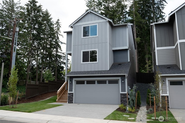 27105 30th Pl S Unit 21, Kent, WA 98032 - view of front of property with board and batten siding, a garage, stairway, stone siding, and concrete driveway
