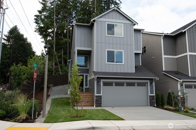 27105 30th Pl S Unit 21, Kent, WA 98032 - view of front of house featuring roof with shingles, driveway, board and batten siding, stone siding, and a garage