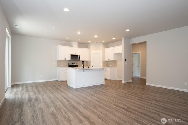 27105 30th Pl S Unit 21, Kent, WA 98032 - kitchen with light wood-style flooring, tasteful backsplash, appliances with stainless steel finishes, open floor plan, and a center island with sink