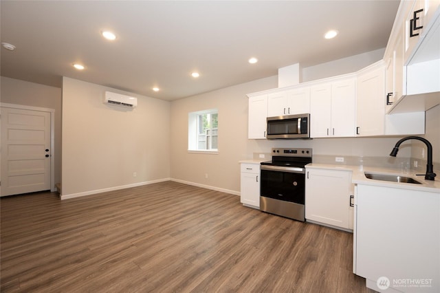27105 30th Pl S Unit 21, Kent, WA 98032 - kitchen with a wall mounted AC, white cabinetry, appliances with stainless steel finishes, a sink, and wood finished floors
