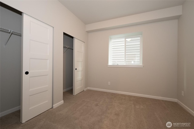 27105 30th Pl S Unit 21, Kent, WA 98032 - unfurnished bedroom with two closets, baseboards, and carpet