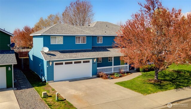 2335 Hawk Dr, Walla Walla, WA 99362 - traditional-style house featuring a shingled roof, driveway, a porch, a front lawn, and an attached garage