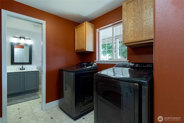 2335 Hawk Dr, Walla Walla, WA 99362 - washroom with visible vents, baseboards, washer and dryer, a sink, and cabinet space