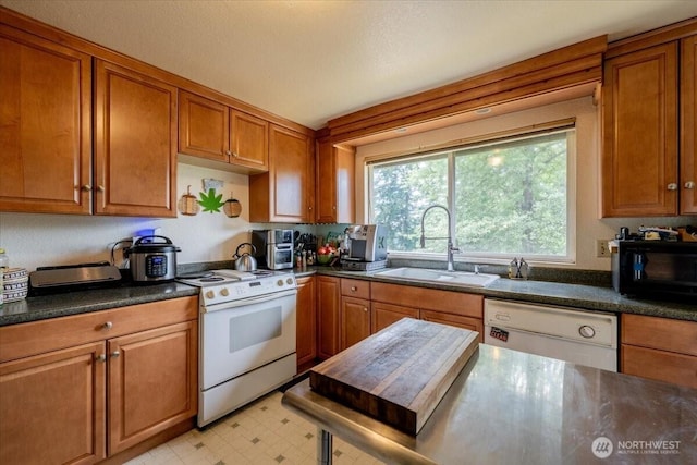 515 N 188th St, Shoreline, WA 98133 - kitchen featuring white appliances, brown cabinetry, dark countertops, and light flooring
