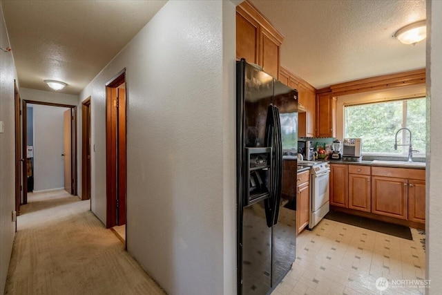 515 N 188th St, Shoreline, WA 98133 - kitchen featuring white electric range, black fridge with ice dispenser, a textured ceiling, brown cabinets, and light floors