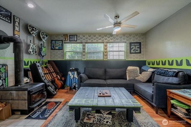 515 N 188th St, Shoreline, WA 98133 - living room featuring a wood stove, ceiling fan, wallpapered walls, and wood finished floors