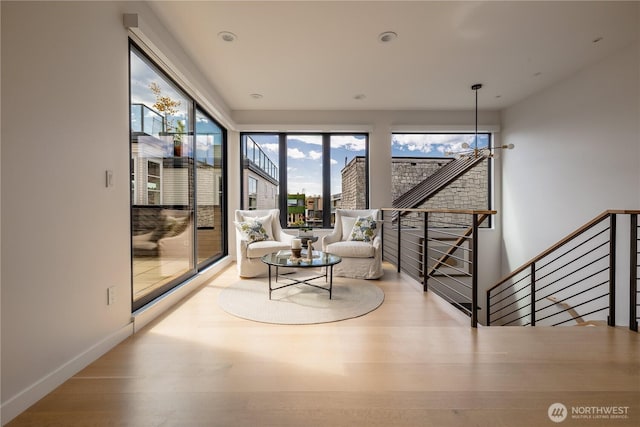 living room with baseboards, wood finished floors, and an inviting chandelier