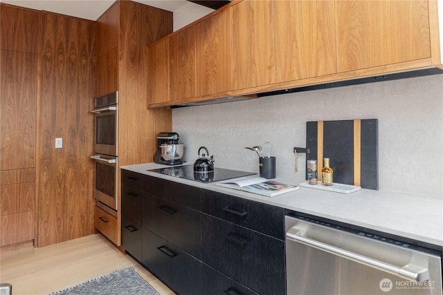 kitchen with light countertops, modern cabinets, light wood-style floors, and stainless steel appliances