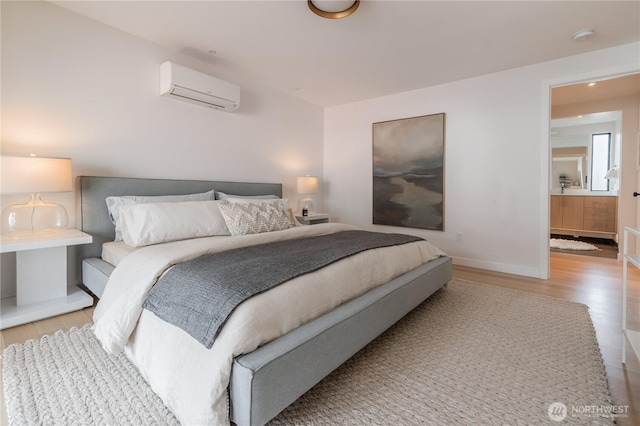 bedroom with baseboards, a wall unit AC, and light wood-type flooring