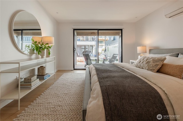 bedroom with access to exterior, wood finished floors, multiple windows, and a wall mounted air conditioner