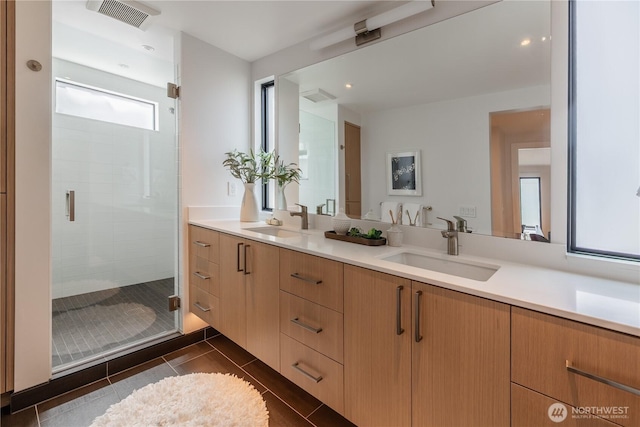 bathroom with double vanity, visible vents, a sink, and a stall shower