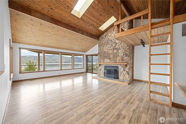 unfurnished living room featuring a stone fireplace, wood finished floors, wooden ceiling, baseboards, and lofted ceiling with skylight