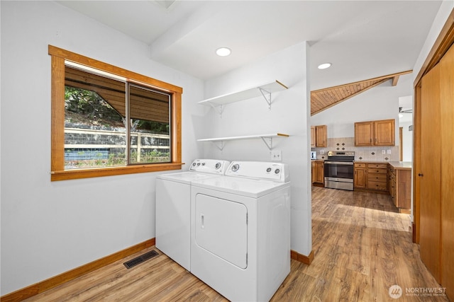 laundry room featuring visible vents, laundry area, light wood-style floors, baseboards, and washing machine and clothes dryer