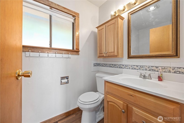 half bathroom featuring vanity and toilet