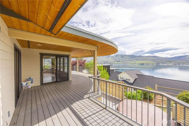 wooden terrace with a water and mountain view