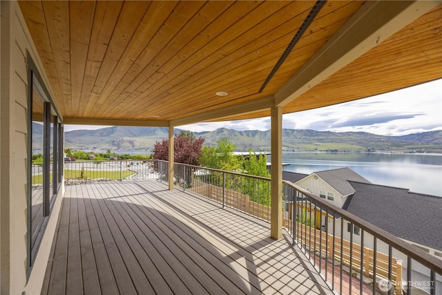 wooden terrace with a water and mountain view