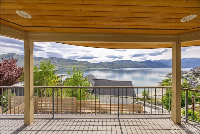 view of patio featuring a balcony and a water and mountain view