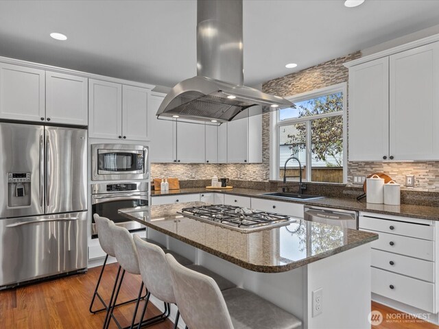 5258 S 285th St, Auburn, WA 98001 - kitchen with island exhaust hood, a center island, dark stone counters, appliances with stainless steel finishes, and a sink