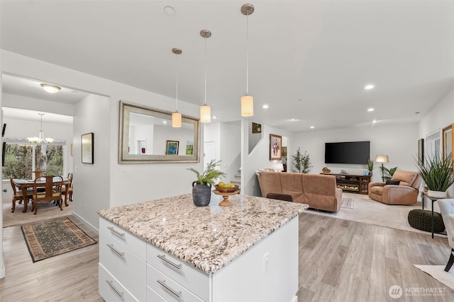 11232 Crescent Valley Dr NW, Gig Harbor, WA 98332 - kitchen with white cabinets, light wood-type flooring, a kitchen island, and light stone counters