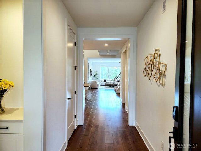 corridor featuring baseboards, recessed lighting, and dark wood finished floors