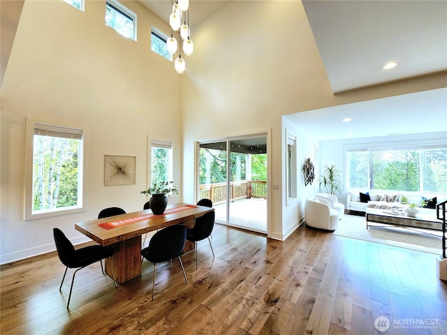 office area featuring a high ceiling, baseboards, and hardwood / wood-style floors