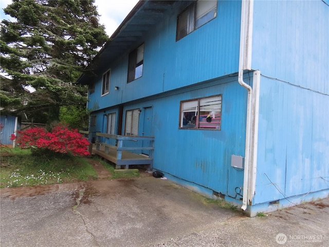 view of property exterior featuring a deck and crawl space