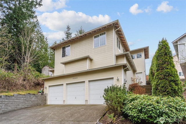view of front of property featuring concrete driveway and an attached garage