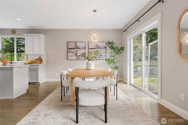 dining area featuring an inviting chandelier, wood finished floors, and baseboards