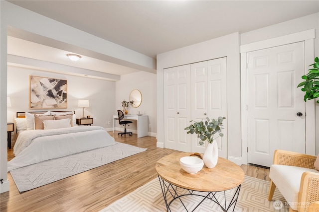 bedroom with baseboards, light wood-style floors, and a closet