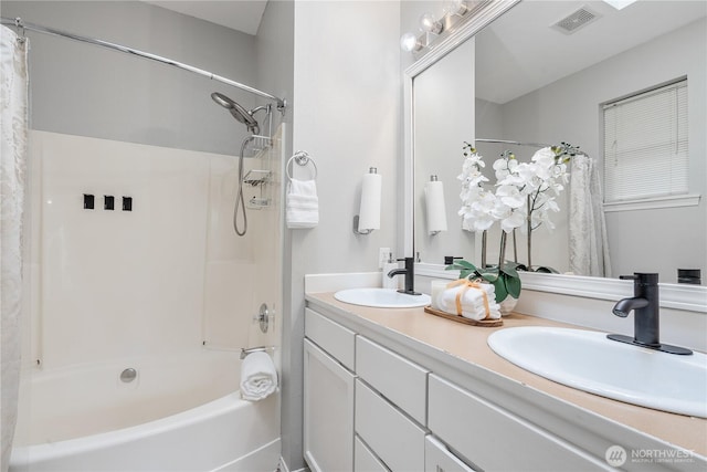 bathroom with visible vents, shower / bath combo, double vanity, and a sink