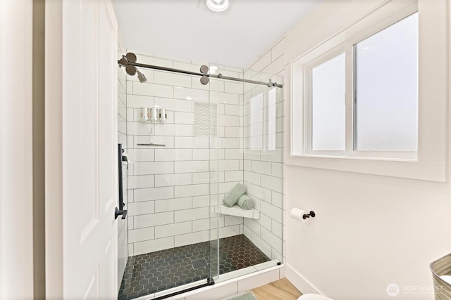 bathroom with a stall shower and wood finished floors