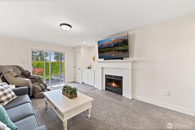 living room with a tile fireplace and baseboards