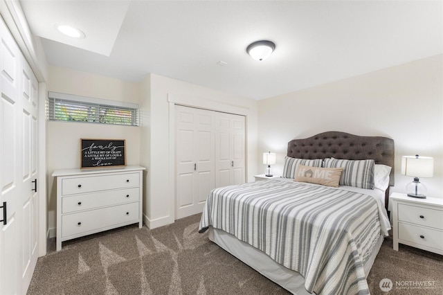 bedroom with a closet, recessed lighting, and dark colored carpet