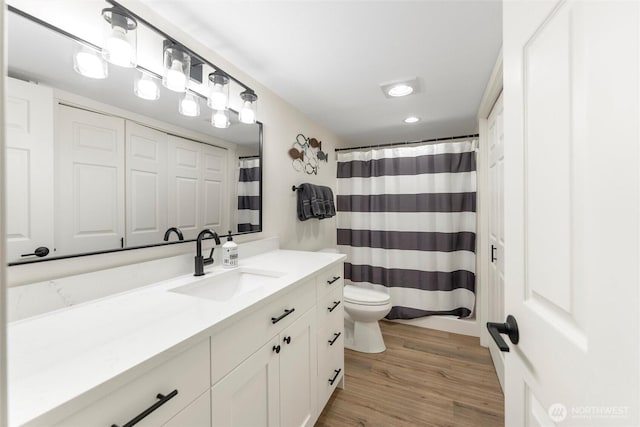 full bathroom featuring toilet, wood finished floors, vanity, and a shower with curtain