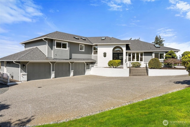 view of front of property with a shingled roof, concrete driveway, and a garage