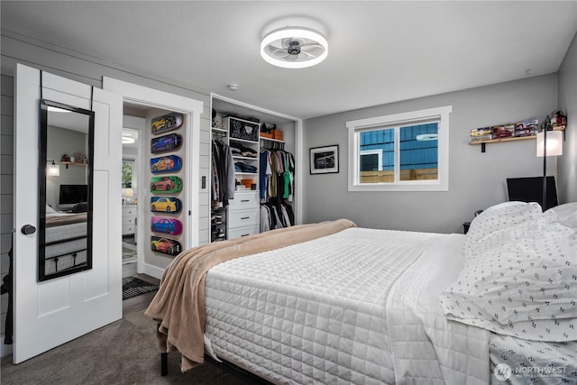 bedroom with dark colored carpet and a closet
