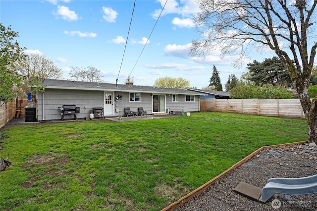 back of property featuring a fenced backyard, a patio, and a lawn