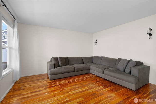 living area with light wood-type flooring and baseboards