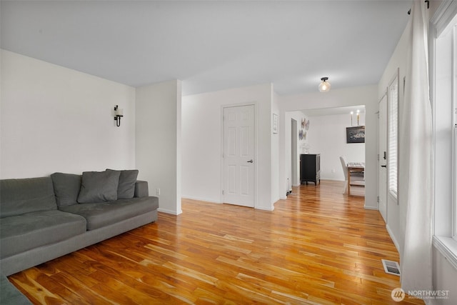 living area with visible vents, baseboards, and light wood-type flooring