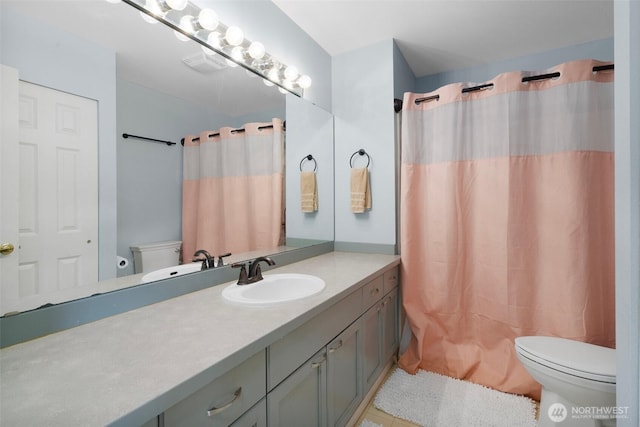 bathroom with toilet, curtained shower, vanity, and visible vents