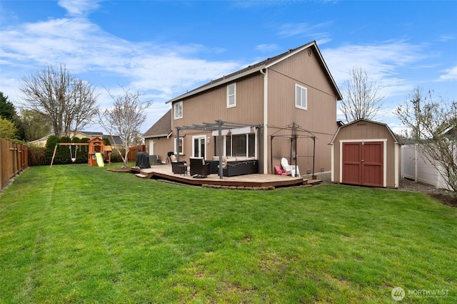back of house featuring a shed, a pergola, a fenced backyard, a playground, and an outbuilding