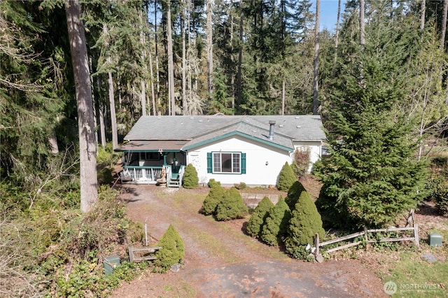 11712 114th Avenue Ct, Anderson Island, WA 98303 - view of front of house featuring driveway, a forest view, fence, and covered porch