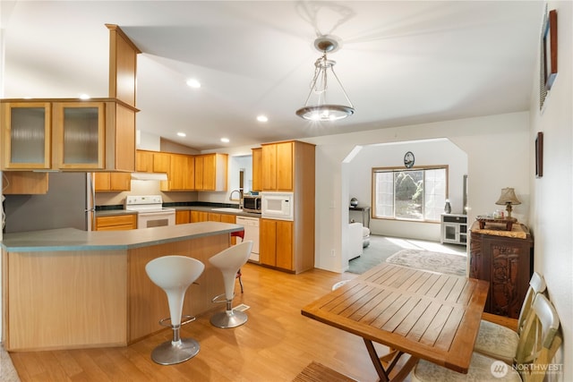 11712 114th Avenue Ct, Anderson Island, WA 98303 - kitchen with light wood finished floors, white appliances, a peninsula, and lofted ceiling
