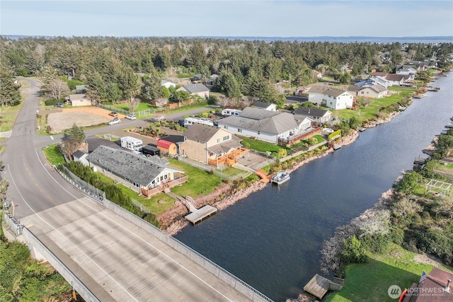 aerial view with a water view, a view of trees, and a residential view