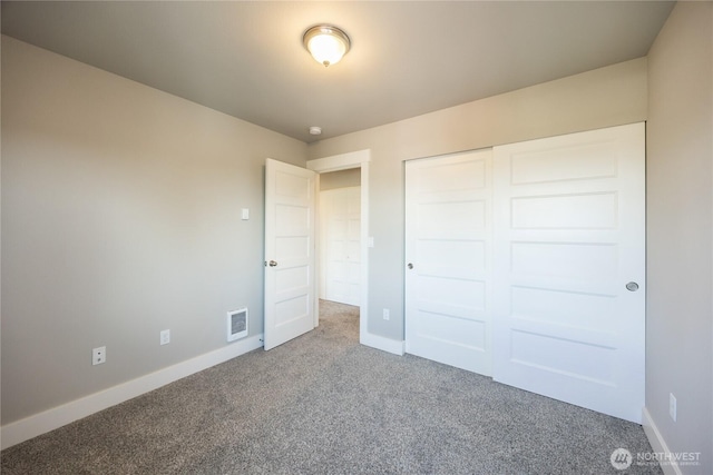 unfurnished bedroom with a closet, carpet flooring, baseboards, and visible vents