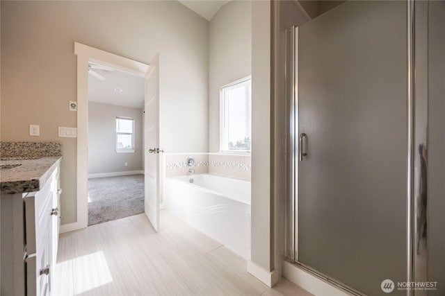 bathroom featuring a shower stall, vanity, and a bath
