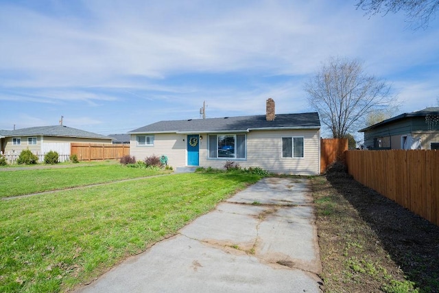 view of front of home with a chimney, fence, and a front lawn