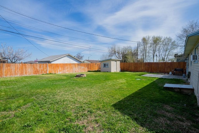 view of yard featuring a storage shed, an outbuilding, and a fenced backyard